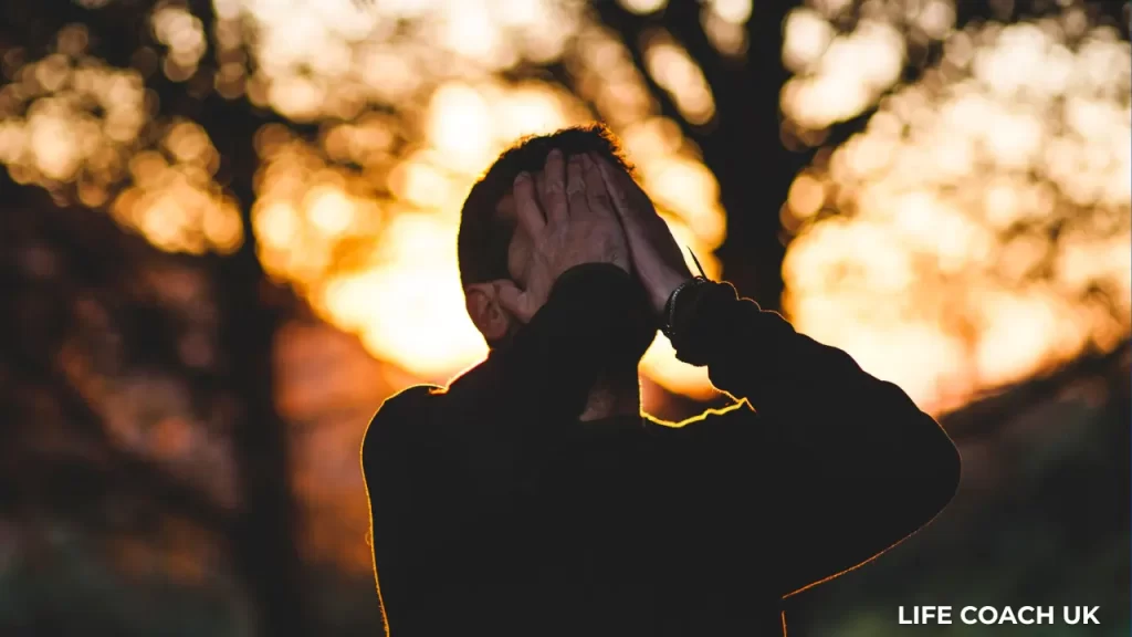 A man losing his temper and holding his head in his hands.